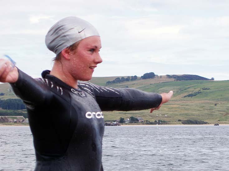 Miranda steps from the water after swiiming across the Firth